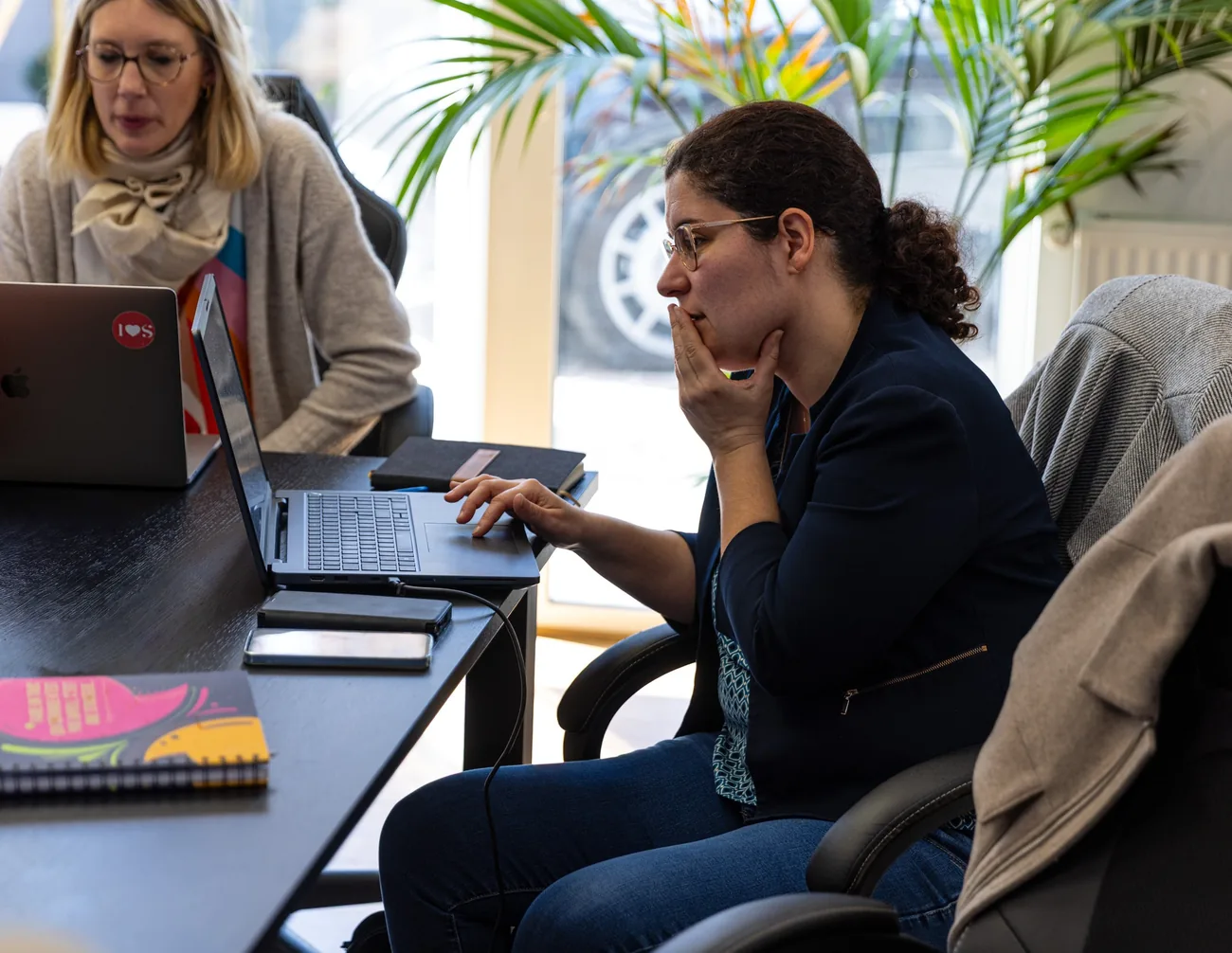 Deux personnes travaillant ensemble sur un document dans les locaux de l'agence Zetruc.