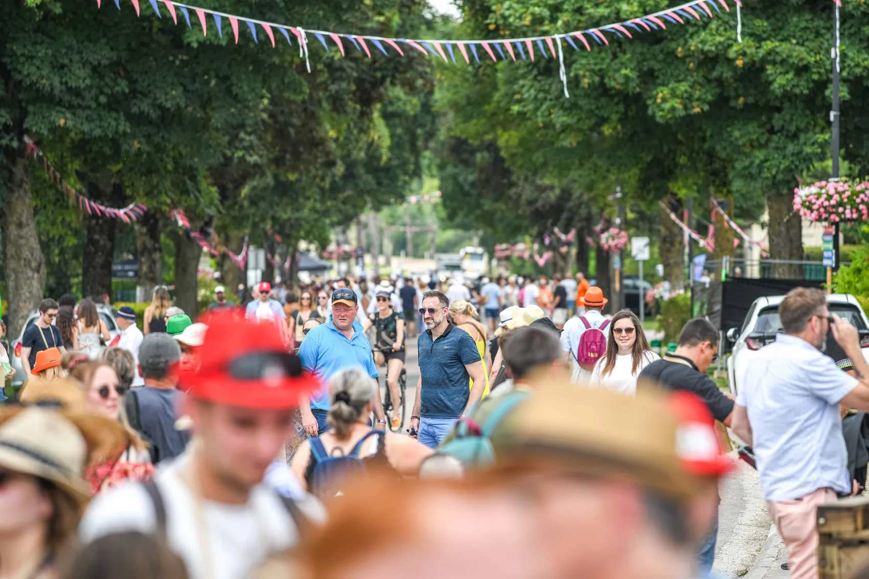 La foule d'une édition de la Route du Champagne en Fête, entre les stands et les guirlandes de l'allée.