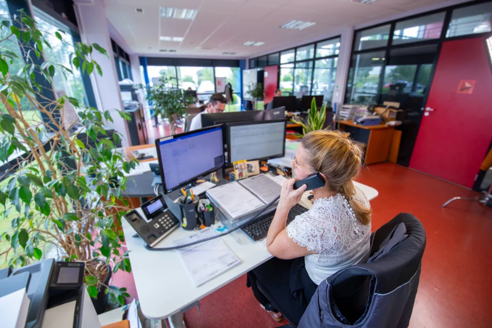 Une collaboratrice de Fame au téléphone devant ses écrans, dans l'open space.