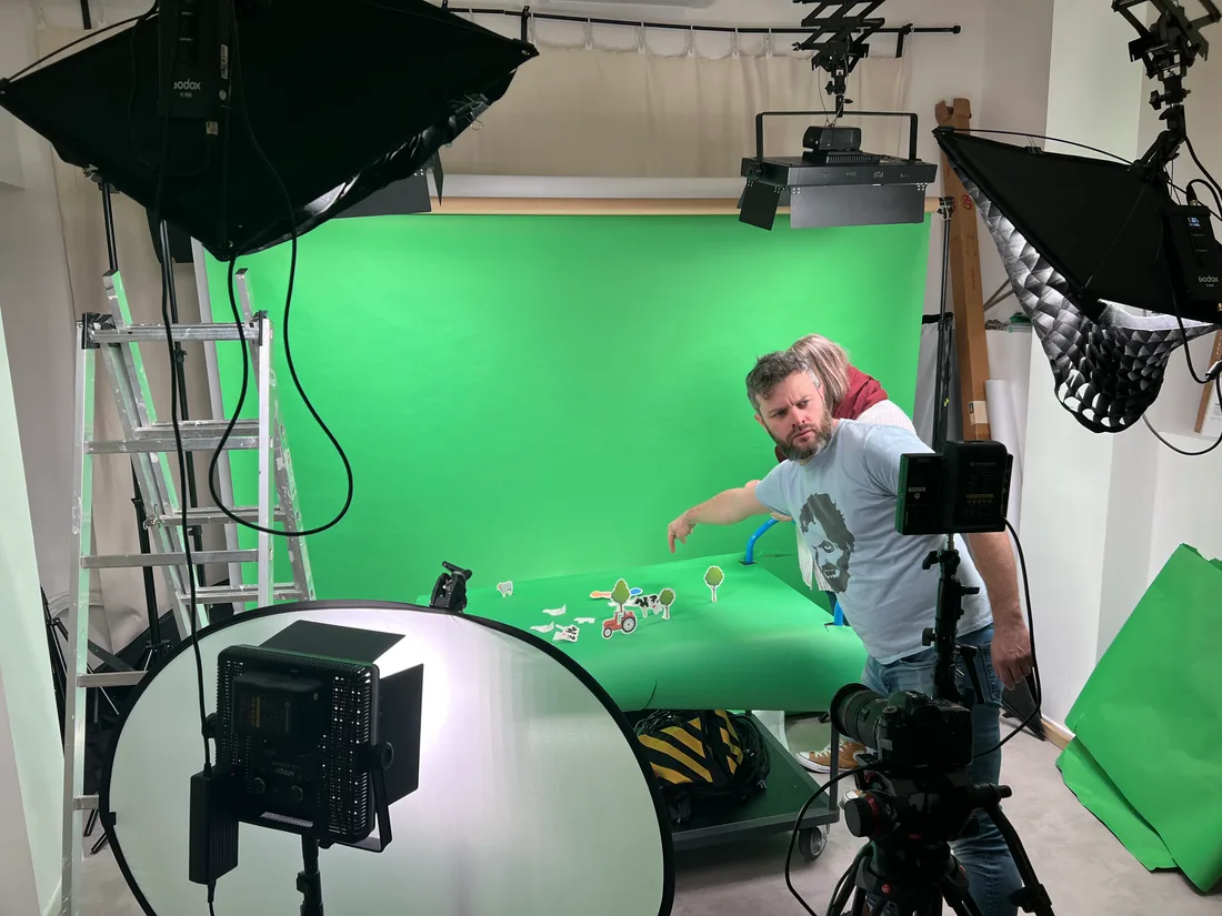 Une mise en scène sur fond vert au studio, entre projecteurs et réflecteur.
